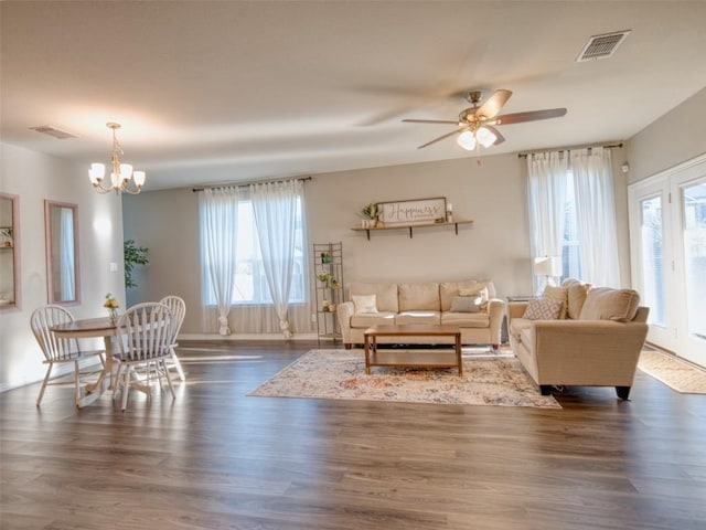 living room with baseboards, dark wood-style floors, visible vents, and a wealth of natural light