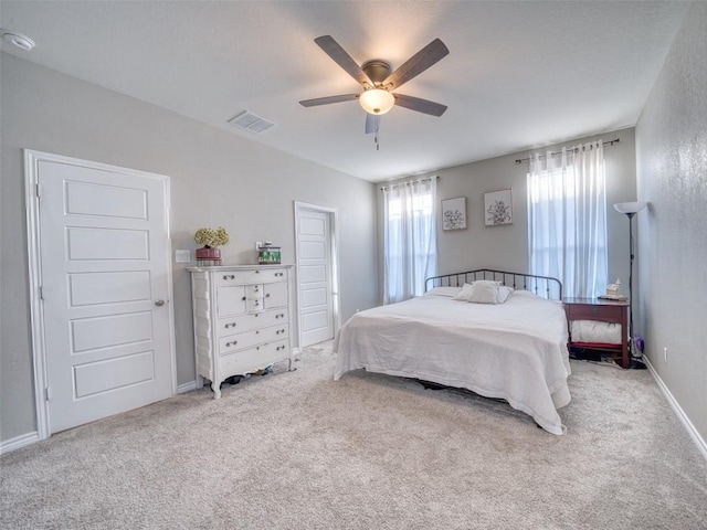 carpeted bedroom featuring visible vents, ceiling fan, and baseboards