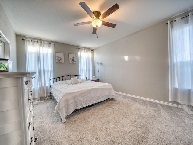carpeted bedroom featuring baseboards and a ceiling fan