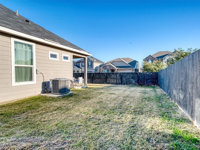 view of yard featuring a fenced backyard, cooling unit, and a residential view