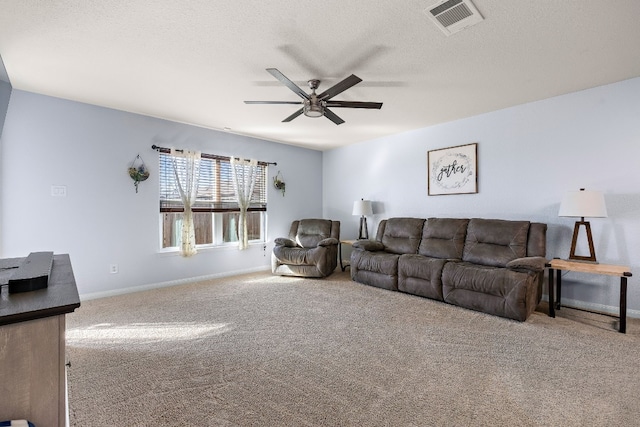 living room with ceiling fan, carpet, and a textured ceiling