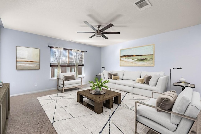 carpeted living room with a textured ceiling and ceiling fan