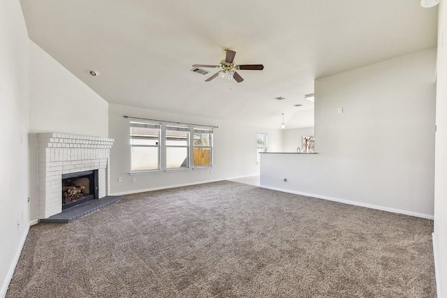 unfurnished living room with ceiling fan, dark carpet, lofted ceiling, and a brick fireplace