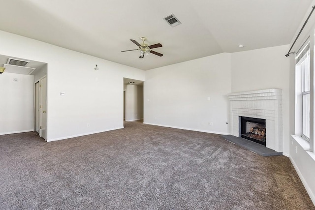 unfurnished living room featuring a fireplace, vaulted ceiling, ceiling fan, and plenty of natural light