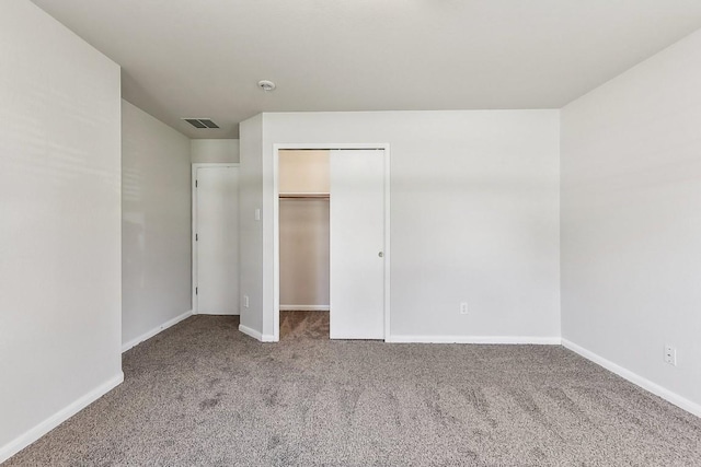 unfurnished bedroom featuring a spacious closet, a closet, and carpet floors