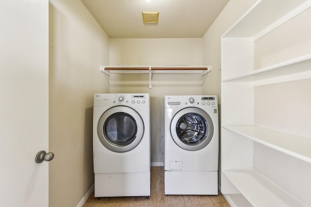 clothes washing area with light tile patterned flooring and washing machine and clothes dryer