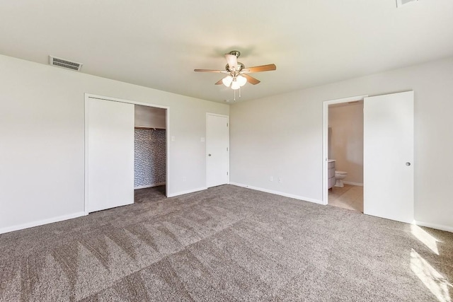 unfurnished bedroom featuring carpet flooring, a closet, ceiling fan, and ensuite bathroom