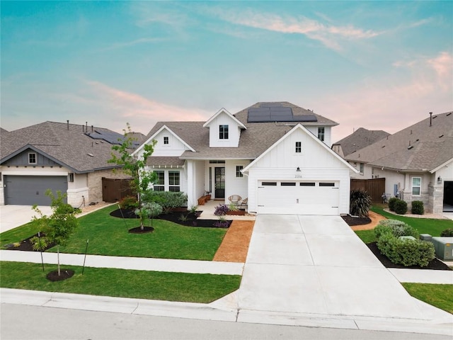 view of front of house featuring solar panels, a yard, and a garage