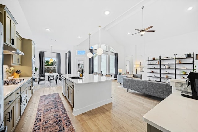 kitchen with ceiling fan, sink, pendant lighting, light hardwood / wood-style floors, and a kitchen island with sink