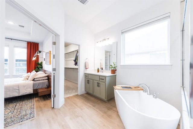 bathroom with hardwood / wood-style floors, vanity, and a bathing tub