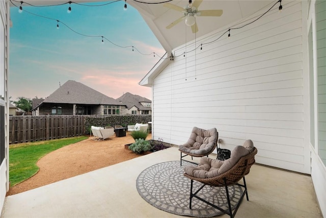 patio terrace at dusk with outdoor lounge area and ceiling fan