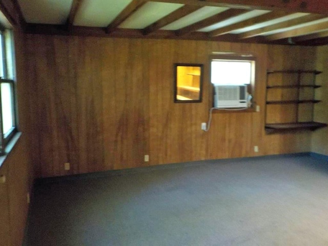 unfurnished room featuring beam ceiling, cooling unit, and wooden walls