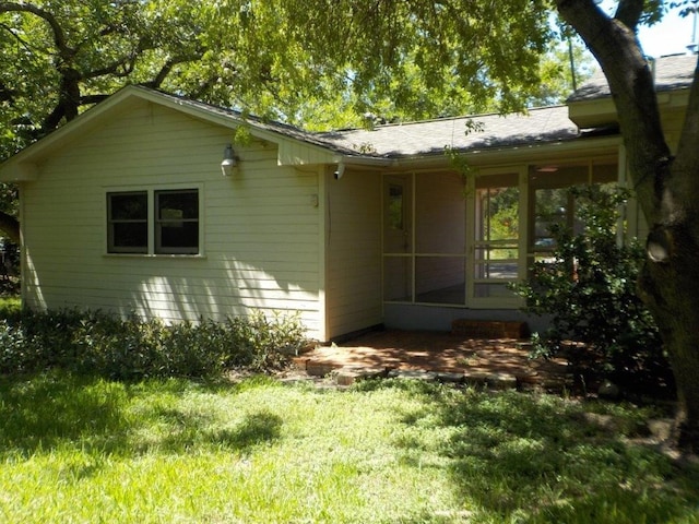 back of house featuring a yard and a sunroom