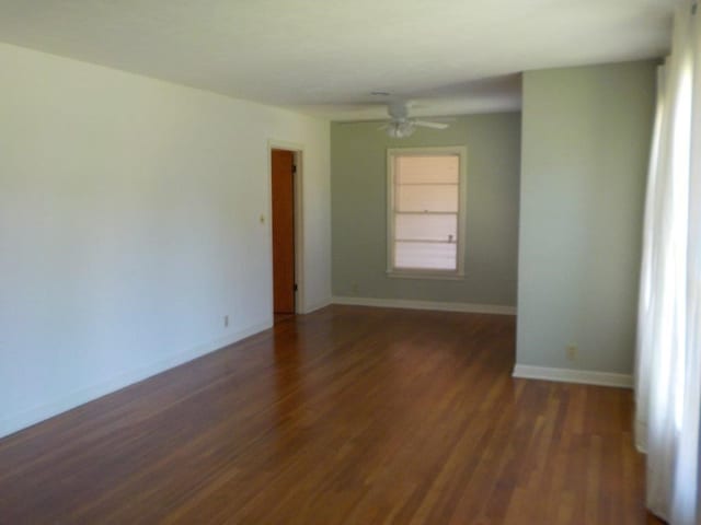 spare room featuring ceiling fan and dark wood-type flooring