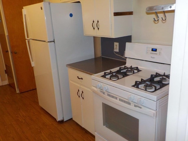 kitchen with white appliances, light hardwood / wood-style floors, and white cabinetry