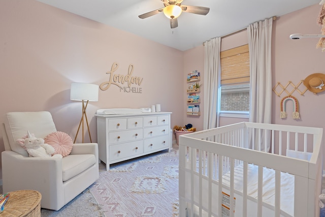 bedroom featuring ceiling fan and a nursery area