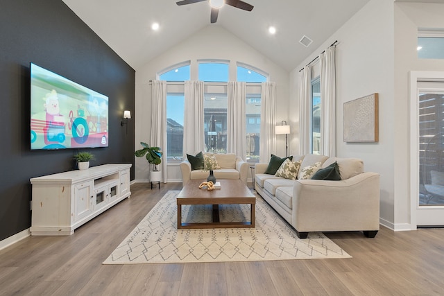 living room with ceiling fan, lofted ceiling, and light hardwood / wood-style floors