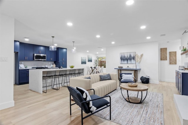 living room featuring light wood-type flooring and sink