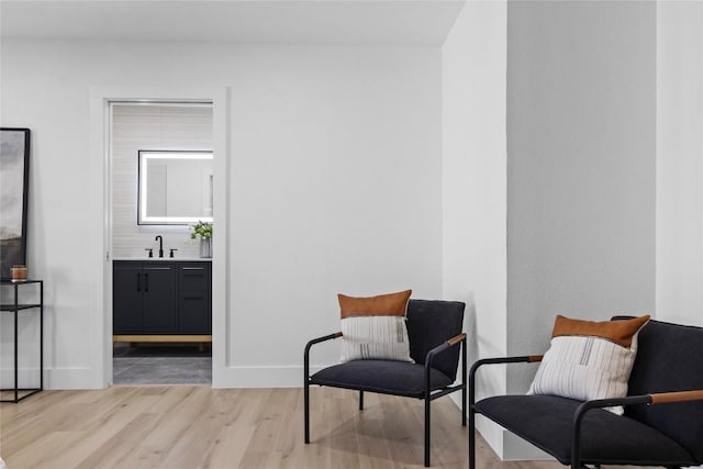 sitting room featuring sink and light hardwood / wood-style flooring