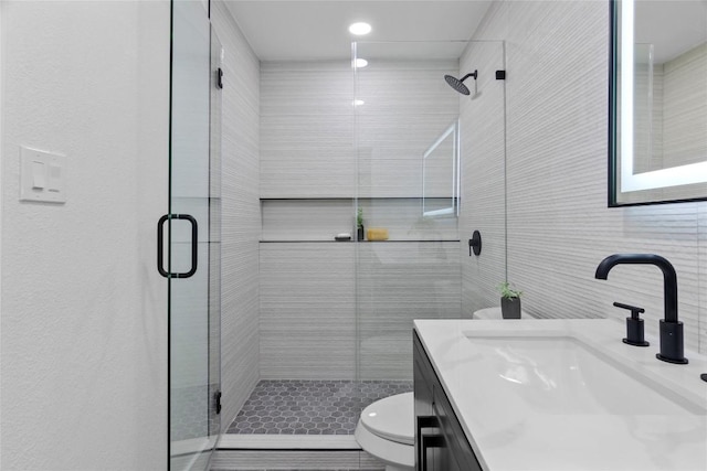 bathroom with an enclosed shower, vanity, toilet, and tasteful backsplash