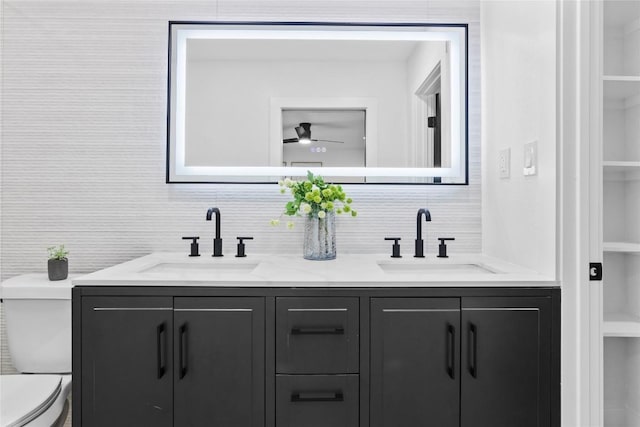 bathroom with vanity, backsplash, ceiling fan, toilet, and built in features