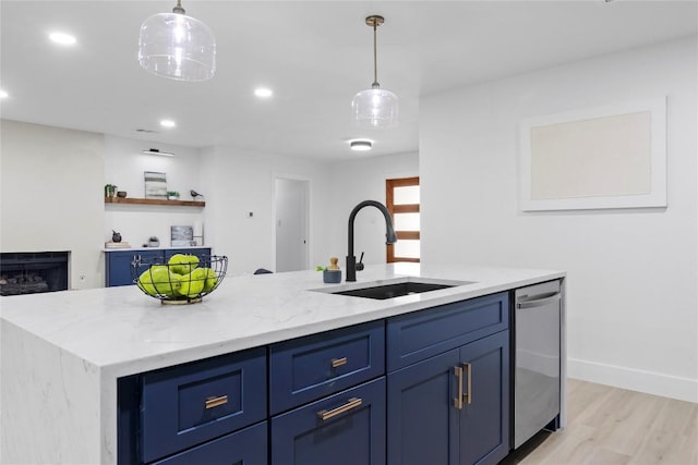 kitchen featuring light stone countertops, sink, dishwasher, blue cabinets, and a kitchen island with sink