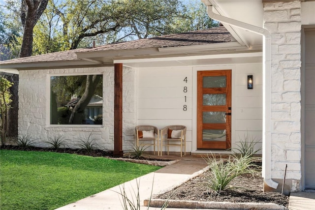 view of exterior entry with a yard