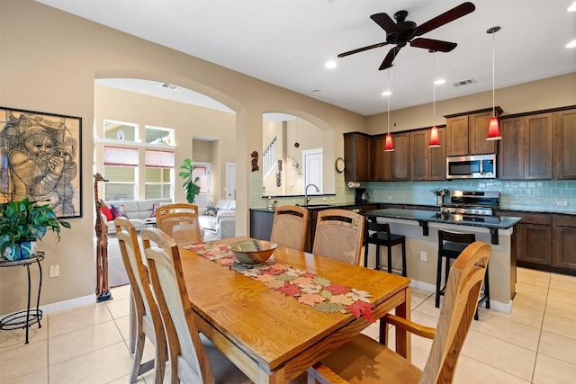 tiled dining area featuring ceiling fan and sink