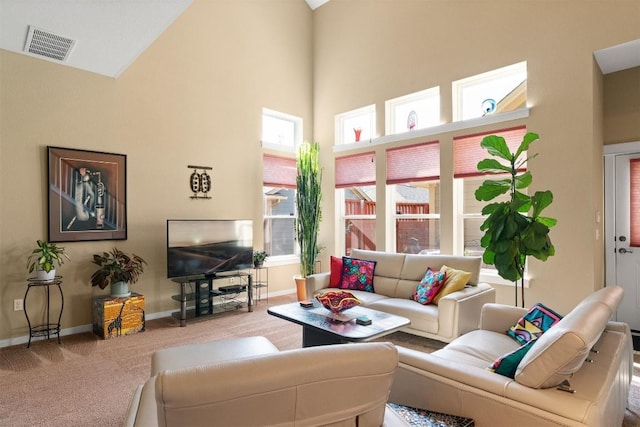 living room featuring carpet flooring and a high ceiling