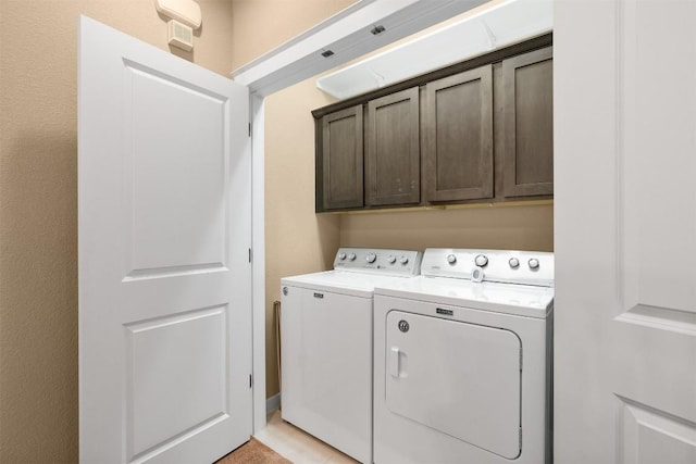 laundry room featuring cabinets and washing machine and clothes dryer