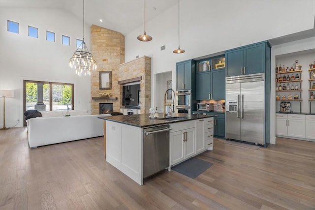 11600 Shoreview Overlook, Austin, TX 78732 - kitchen with stainless steel appliances, high vaulted ceiling, wood finished floors, open floor plan, and glass insert cabinets