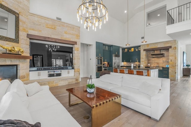 11600 Shoreview Overlook, Austin, TX 78732 - living room with high vaulted ceiling, light wood finished floors, a fireplace, recessed lighting, and a chandelier
