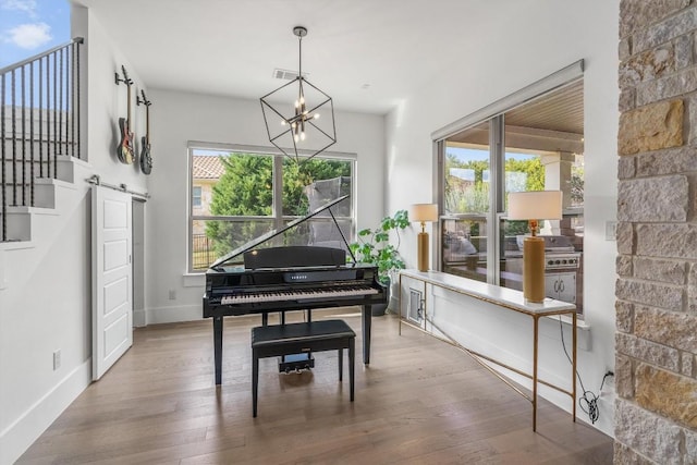 miscellaneous room featuring a chandelier, hardwood / wood-style floors, and a healthy amount of sunlight