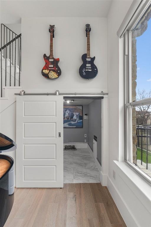 clothes washing area with a barn door and hardwood / wood-style floors