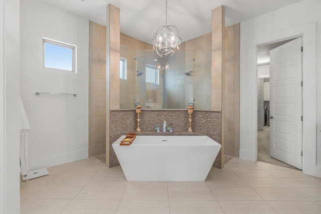 bathroom with tile patterned flooring, shower with separate bathtub, and an inviting chandelier