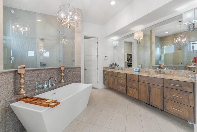 bathroom featuring tile patterned floors, vanity, plus walk in shower, and an inviting chandelier