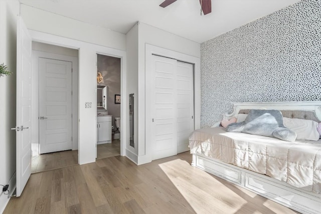 11600 Shoreview Overlook, Austin, TX 78732 - bedroom with wood finished floors, a closet, a ceiling fan, an accent wall, and ensuite bathroom