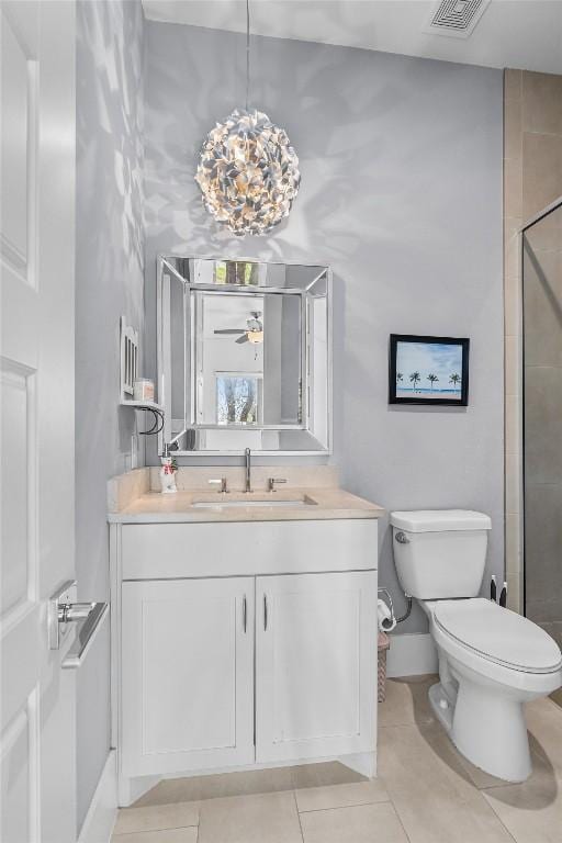 bathroom featuring tile patterned floors, vanity, a tile shower, toilet, and visible vents