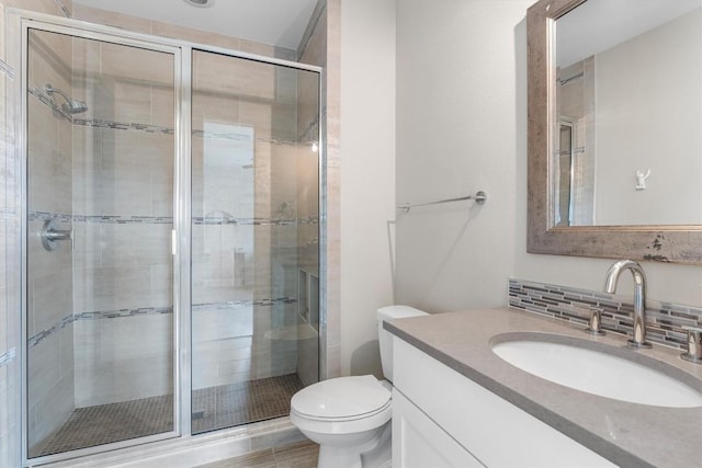 bathroom featuring decorative backsplash, vanity, toilet, and walk in shower