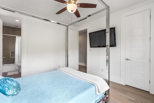 bedroom featuring hardwood / wood-style floors, ceiling fan, and ensuite bathroom