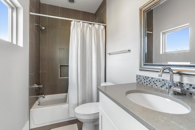 full bathroom featuring vanity, decorative backsplash, toilet, a healthy amount of sunlight, and shower / tub combo