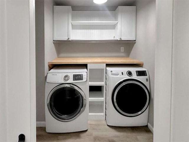 clothes washing area featuring cabinets and independent washer and dryer