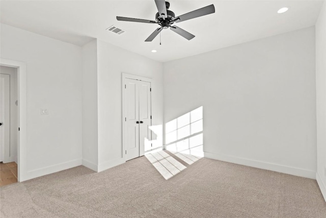 carpeted empty room featuring ceiling fan