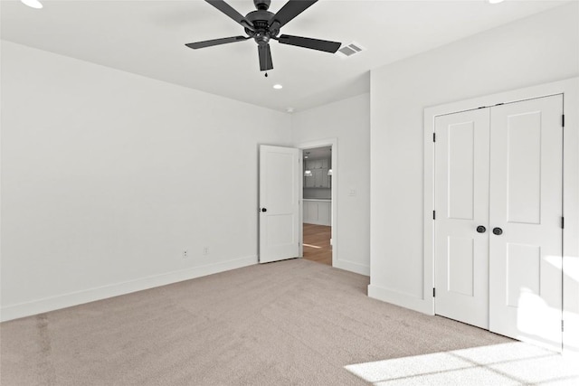 unfurnished bedroom with a closet, ceiling fan, and light colored carpet