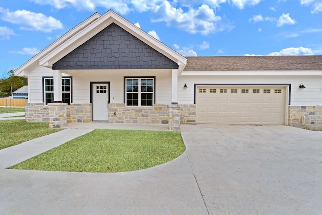 view of front of house with a porch, a garage, and a front lawn