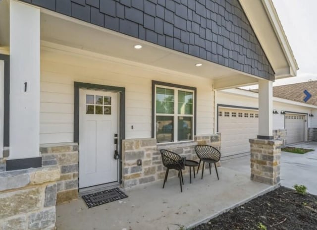 view of exterior entry with covered porch and a garage