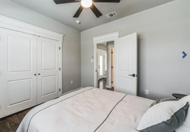 bedroom with ceiling fan, dark wood-type flooring, and a closet