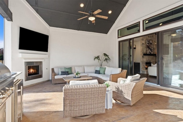 view of patio with an outdoor living space with a fireplace and ceiling fan