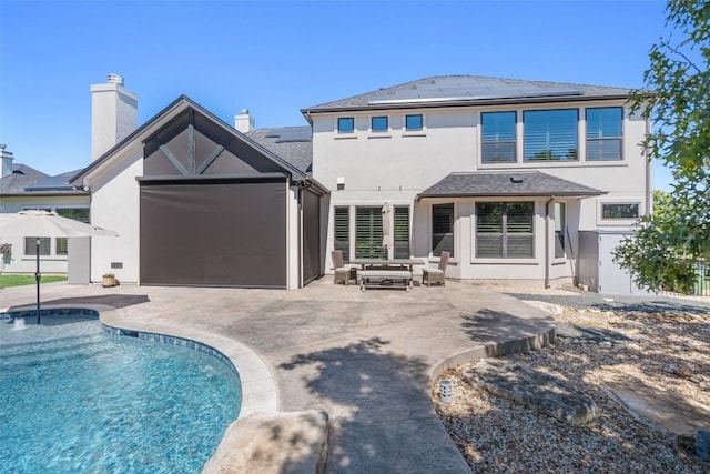 rear view of property with solar panels and a patio