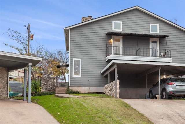 view of front of house featuring a front yard, a balcony, and a carport